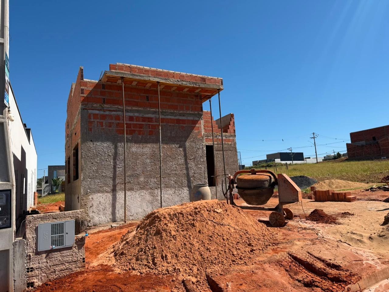 Obra em fase de alvenaria e laje, com escoramento metálico e blocos cerâmicos aparentes