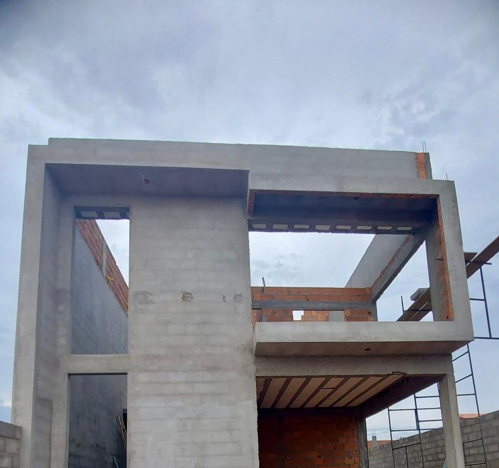 Sobrado em obra com estrutura de concreto, vãos abertos e escoramento do pavimento superior